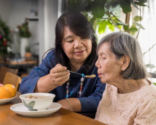 Caregiver helping feed woman