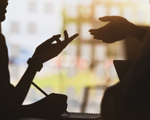 Shadow of hands of two people talking